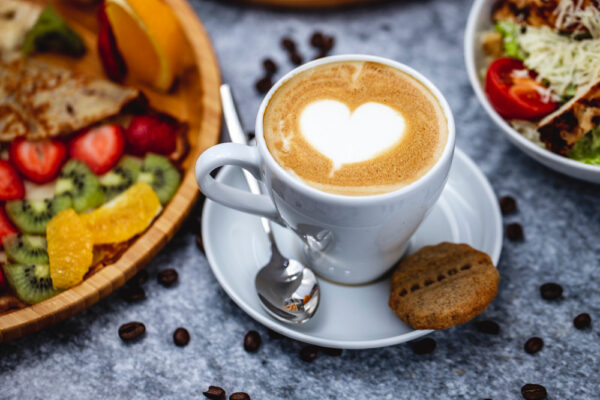 Cappuccino cu inimă latte art și mic dejun