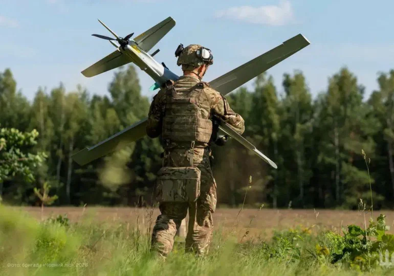 Soldat transportă dronă militară pe câmp