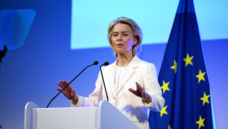 Femeie vorbind la pupitru, steagul Uniunii Europene.